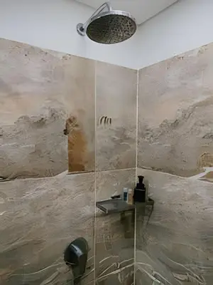 a bathroom with a shower with a stone wall at Suite Frente al Mar en Cartagena 1410 in Cartagena de Indias