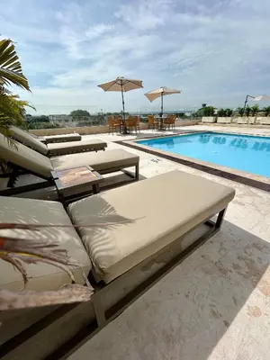 a swimming pool with several lounge chairs and a swimming pool at Suite Frente al Mar en Cartagena 1410 in Cartagena de Indias