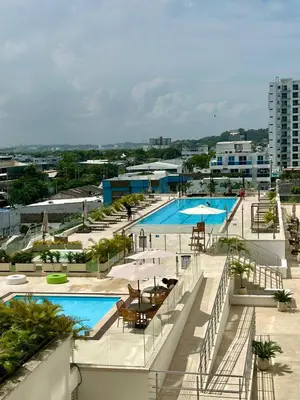 a large pool with tables and umbrellas on a building at Apartamento Moderno en Cartagena 1546 in Cartagena de Indias