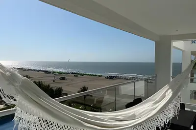 a hammock on a balcony overlooking a beach at Apto en Morros 3 con vista al Mar 504 in Cartagena de Indias