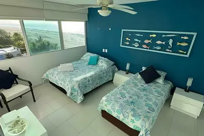 a bedroom with two beds and a couch and a window at Apto en Morros 3 con vista al Mar 504 in Cartagena de Indias