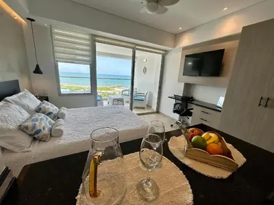 a room with a bed and a table with wine glasses at Suite con vista al mar Cartagena CB808 in Cartagena de Indias