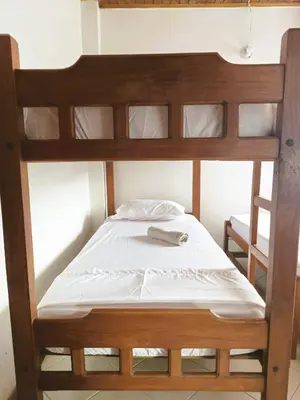 a bunk bed with white sheets and a book on it at Amplio y Luminoso Apto en Tolú in Santiago