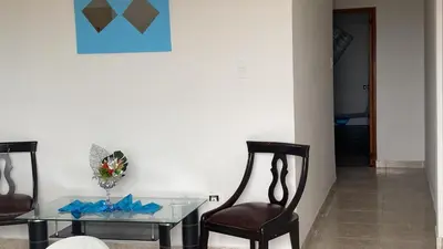 a dining room with a glass table and two chairs at Apartamentos las palmas in Cartagena de Indias