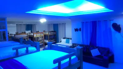 a room with blue lights and beds in it at Apartamentos las palmas in Cartagena de Indias