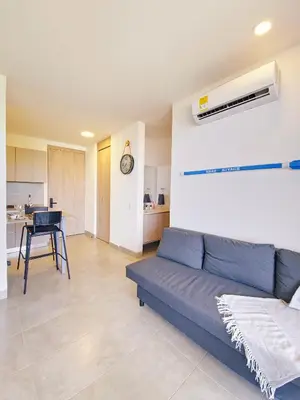 a living room with a blue couch and a kitchen at VILLA LILI Santa Marina Santa Marta in Santa Marta
