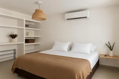 a bedroom with a bed with white walls and white shelves at Hermoso apartamento cerca del Hotel Las Americas y Playa Azul in Cartagena de Indias