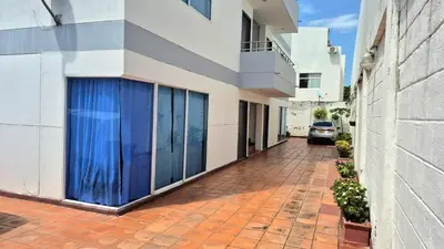 a building with a blue garage door on a sidewalk at Hermoso apartamento cerca del Hotel Las Americas y Playa Azul in Cartagena de Indias