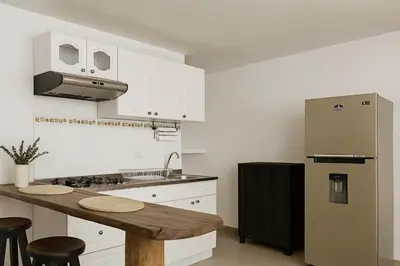 a kitchen with a refrigerator and a wooden counter top at Hermoso apartamento cerca del Hotel Las Americas y Playa Azul in Cartagena de Indias