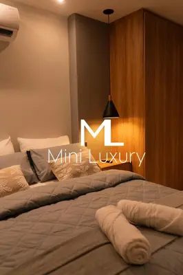 a large bed with a lit m sign on the wall at apartamento miniluxxury in Barranquilla