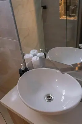 a white sink in a bathroom with towels on a counter at apartamento miniluxxury in Barranquilla