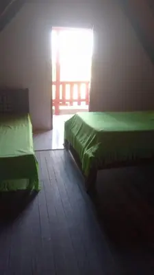 a bedroom with two beds in a room with a window at Refugio olgamar, Cabaña con kiosco cerca al mar in Moñitos