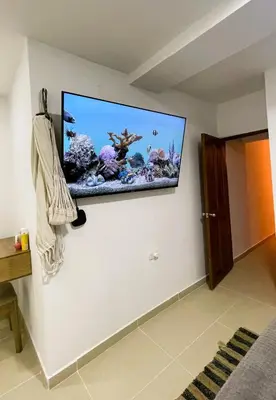 a flat screen tv on a wall with an aquarium at Escapate a Tolú - Lindo Apartamento in Santiago