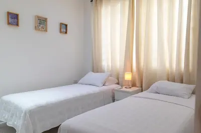 two beds in a room with a lamp on a table at edificio Alba in Cartagena de Indias