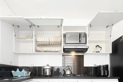 a kitchen with white cabinets and a microwave at edificio Alba in Cartagena de Indias