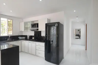 a black refrigerator in a kitchen with white cabinets at edificio Alba in Cartagena de Indias