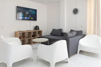 a living room with a couch and white chairs at edificio Alba in Cartagena de Indias