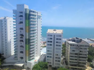 two tall buildings with the ocean in the background at Cartagena Beach con vista al mar in Cartagena de Indias