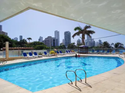 a large swimming pool with chairs and a city skyline at Cartagena Beach con vista al mar in Cartagena de Indias