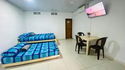 a bedroom with two bunk beds and a table at Mayo Habitación Tolu in Tolú