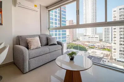 a living room with a couch and a table in front of a window at DUPLEX DE LUJO CON VISTA AL MAr in Cartagena de Indias