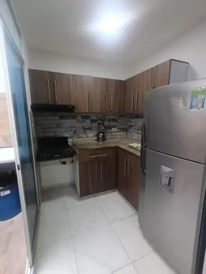 a kitchen with wooden cabinets and a stainless steel refrigerator at Rincón Barranquilla CERCA DE TODO in Barranquilla