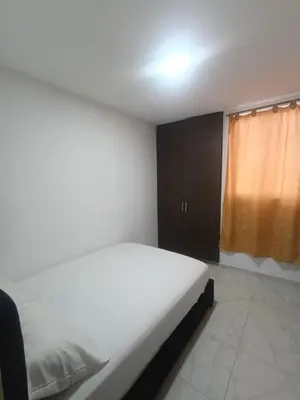 a bedroom with a white bed and a brown cabinet at Rincón Barranquilla CERCA DE TODO in Barranquilla