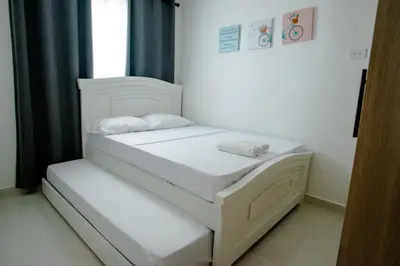 a white bed in a room with a window at Apartamento Cartagena Playa 2203 in Cartagena de Indias