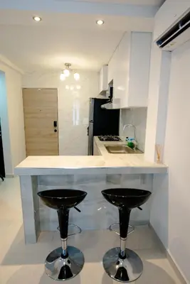 a kitchen with two bar stools and a counter top at Apartamento Cartagena Playa 2203 in Cartagena de Indias