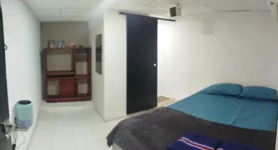 a bedroom with a bed and a cabinet in it at casa perla del mar in Cartagena de Indias