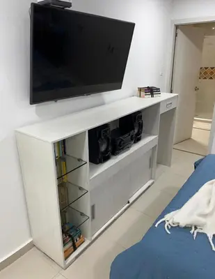 a white entertainment center with a flat screen tv on a wall at Apartamento Vacacional en Bocagrande in Cartagena de Indias