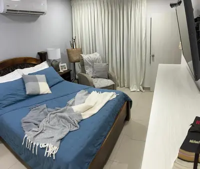 a bedroom with a blue bed and a chair at Apartamento Vacacional en Bocagrande in Cartagena de Indias