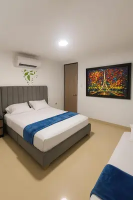 a bedroom with a bed and a painting on the wall at Apartamentos CP in Barranquilla