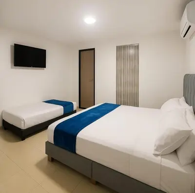 a bedroom with two beds and a flat screen tv at Apartamentos CP in Barranquilla