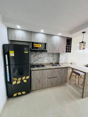 a kitchen with a black refrigerator and a sink at Apartamento lujoso en Cartagena in Cartagena de Indias
