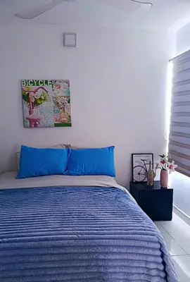 a bedroom with a bed with a blue comforter at Lindo apartamento in Cartagena de Indias