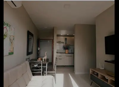 a living room with a white couch and a kitchen at Lindo apartamento in Cartagena de Indias