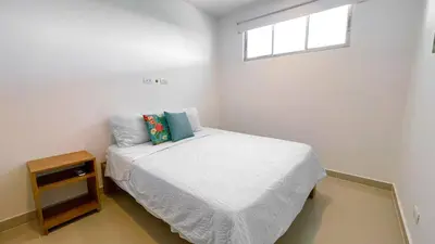 a small bedroom with a bed and a window at Magico Apartamento Frente al Mar 3 Habitaciones AR42 in Coveñas