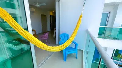 a balcony with a hammock and two chairs at Magico Apartamento Frente al Mar 3 Habitaciones AR42 in Coveñas
