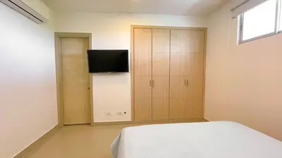 a bedroom with a bed and a cabinet with a television at Magico Apartamento Frente al Mar 3 Habitaciones AR42 in Coveñas