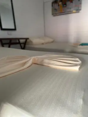 a white bed with a white sheet on it at Brisas del Mar Barú in Playa Blanca