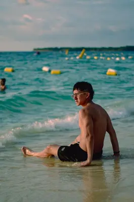 a man sitting on a surfboard in the ocean at Brisas del Mar Barú in Playa Blanca