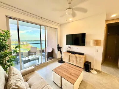 a living room with a couch and a flat screen tv at Hermoso apartamento con vista al mar in Santa Marta
