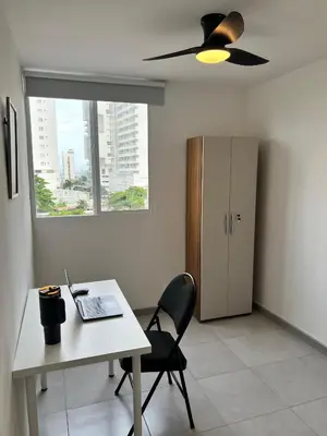 a room with a desk with a laptop and a refrigerator at Apartamento cerca al mar y centro histórico in Cartagena de Indias