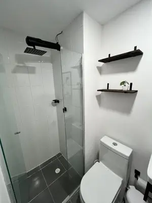 a bathroom with a toilet and a glass shower at Apartamento cerca al mar y centro histórico in Cartagena de Indias