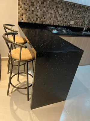 two chairs and a counter with a black counter top at Manglar - Ciudad Mallorquin in Puerto Colombia