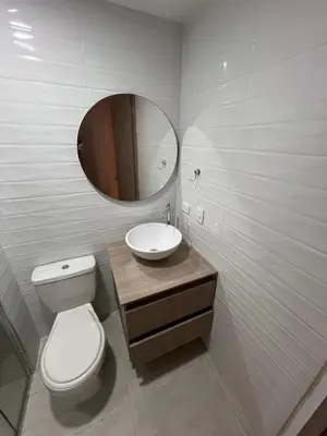 a bathroom with a toilet and a sink and a mirror at Manglar - Ciudad Mallorquin in Puerto Colombia