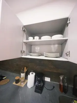 a kitchen with white shelves with plates and utensils at Apartamento frente al mar in Cartagena de Indias
