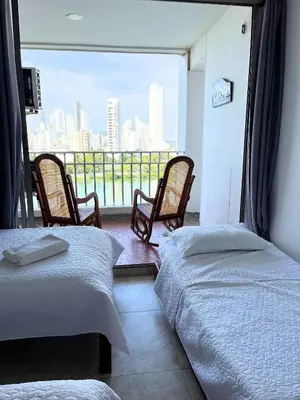two beds in a room with a view of a city at Hermoso apartamento con vista en el laguito in Cartagena de Indias
