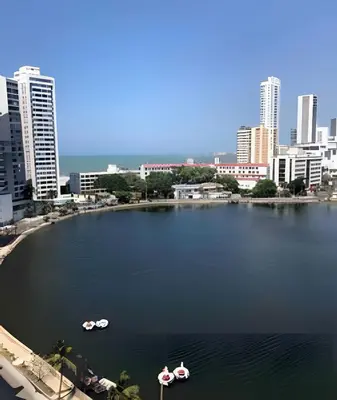 two boats in a large body of water in a city at Hermoso apartamento con vista en el laguito in Cartagena de Indias